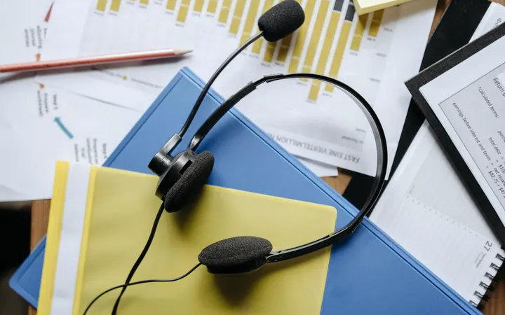 Support headset resting on a desk of documents